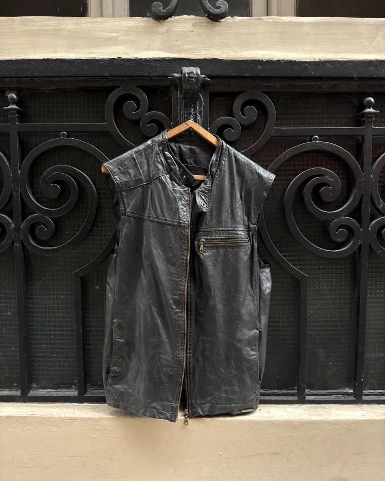 Chaleco de cuero negro vintage colgado en el frente del local de Vintro Vintage