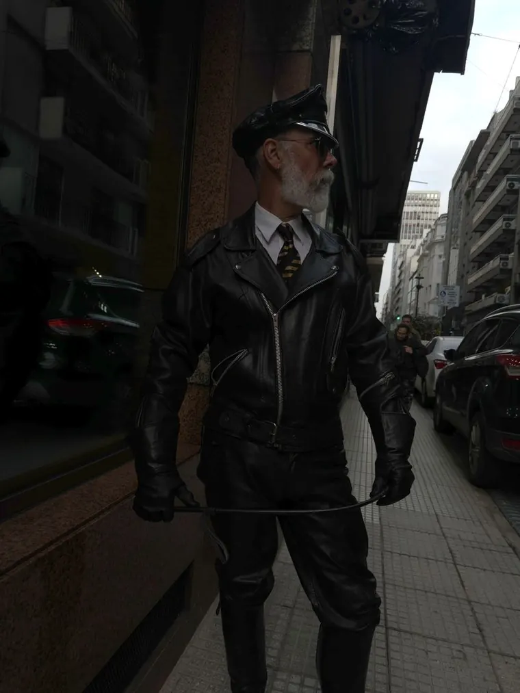 Héctor con conjunto de cuero negro y gorra vintage